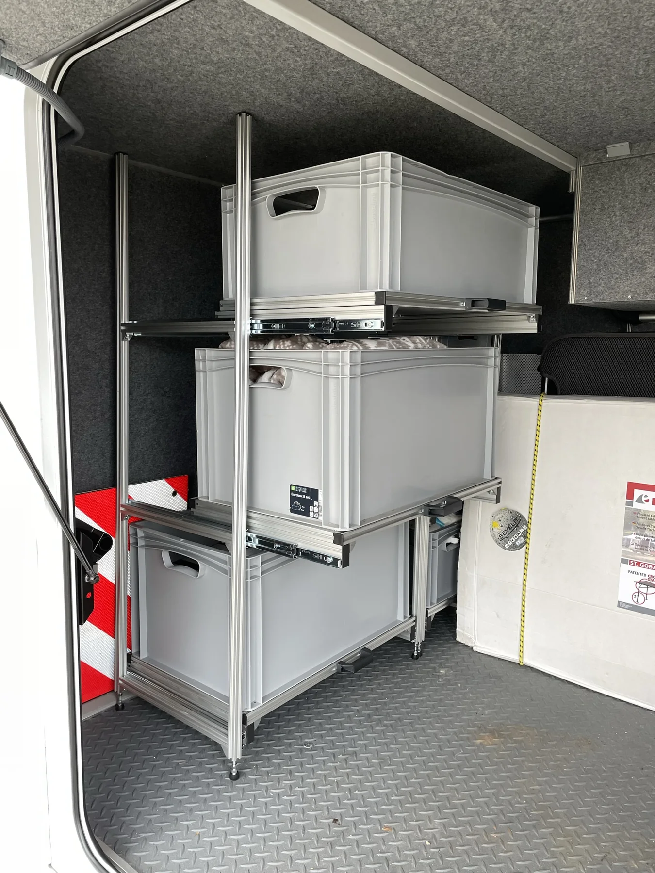 Maßgefertigtes Aluminium-Regalsystem mit ausziehbaren Boxen in einer Wohnmobilgarage